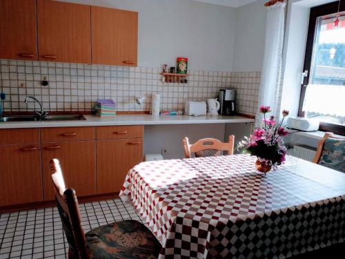 a kitchen with a table with a vase of flowers on it at Ferienwohnung Stocker in Traitsching