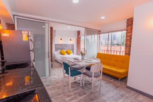a room with a table and chairs and a bed at ApartaSuites & Hotel Bogota Suamox in Bogotá