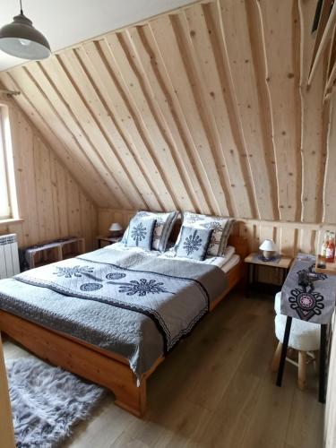 a bedroom with a bed with a wooden ceiling at VILLA JAGODOVO Biały Dunajec in Biały Dunajec