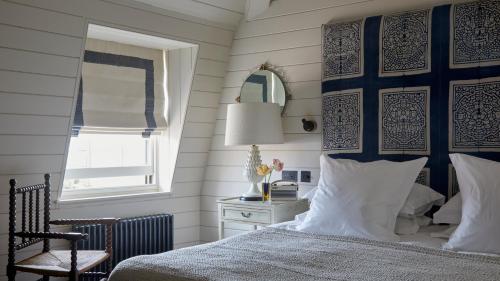 a bedroom with a bed and a chair and a window at The George In Rye in Rye