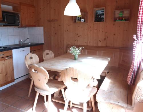 cocina con mesa de madera con sillas y fregadero en Chalet Chocolat, en Hohentauern