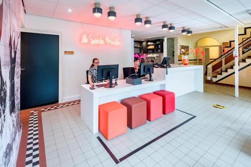 a store with two women standing at a counter with a computer at Kloosterhotel de Soete Moeder in Den Bosch