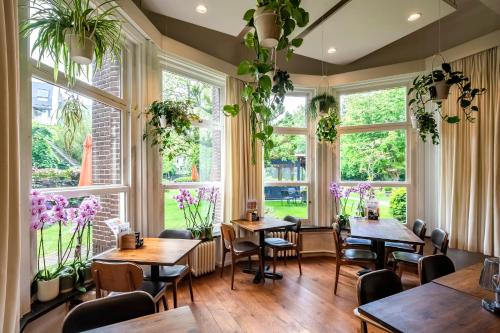 デンボスにあるKloosterhotel de Soete Moederのテーブルと椅子と窓のあるレストラン