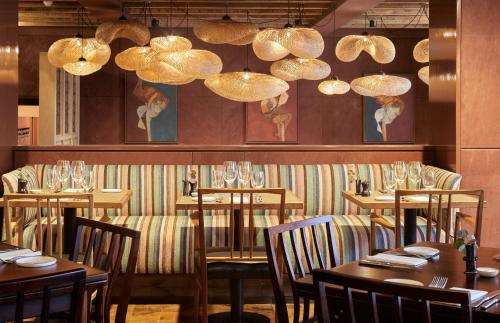 a dining room with tables and chairs and chandeliers at The George In Rye in Rye