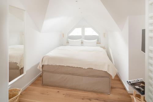 - une chambre blanche avec un grand lit dans l'établissement Haus Salz&Sand Lüttje Tide, à Norderney