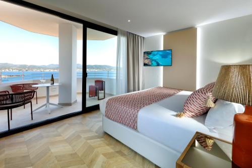 a hotel room with a bed and a view of the ocean at TRS Ibiza Hotel - Adults Only in San Antonio