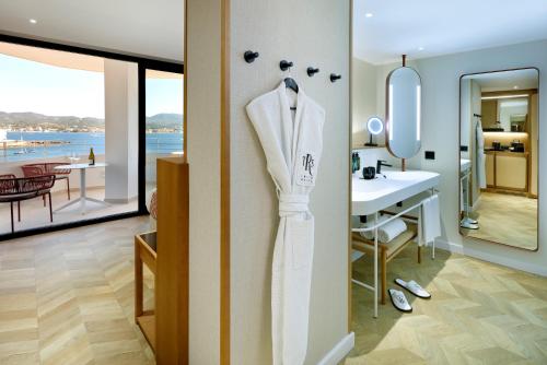 a white robe hanging on a wall in a bathroom at TRS Ibiza Hotel - Adults Only in San Antonio