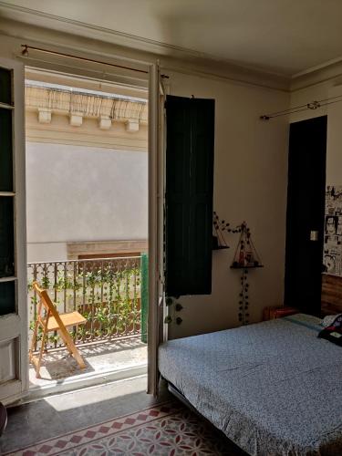 a bedroom with a bed and a sliding glass door at Habitación en el centro barcelona in Barcelona
