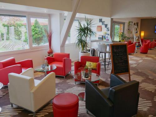 a waiting room with red chairs and a counter at ibis Nemours in Nemours