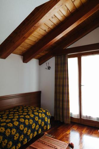 a bedroom with a bed and two large windows at Hotel Walser Courmayeur in Courmayeur