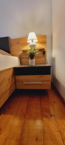 a bedroom with a bed with a table with a lamp on it at Apartma Metka Bovec in Bovec