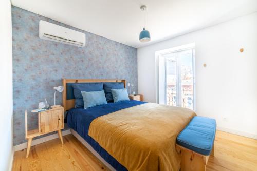 um quarto com uma cama com uma colcha azul em Blue by the River 4 - Unique Penthouse Duplex with a View em Lisboa