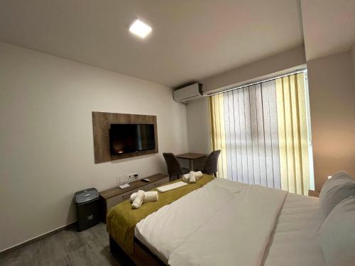 ein Schlafzimmer mit einem großen Bett und einem TV in der Unterkunft Darki Apartment 2 - Very Central Stay With Free Parking in Ohrid