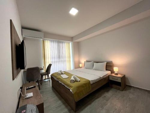 Schlafzimmer mit einem Bett, einem TV und einem Schreibtisch in der Unterkunft Darki Apartment 2 - Very Central Stay With Free Parking in Ohrid