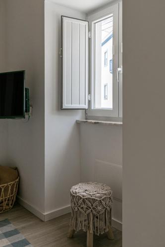 a room with a stool and a window at Casa da Saudade in Ferrel