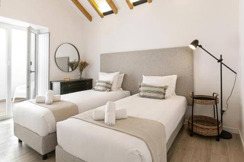 2 weiße Betten in einem Zimmer mit Spiegel in der Unterkunft Casa da Saudade in Ferrel