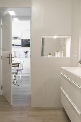 a white kitchen with a sink and a table at Casa da Saudade in Ferrel