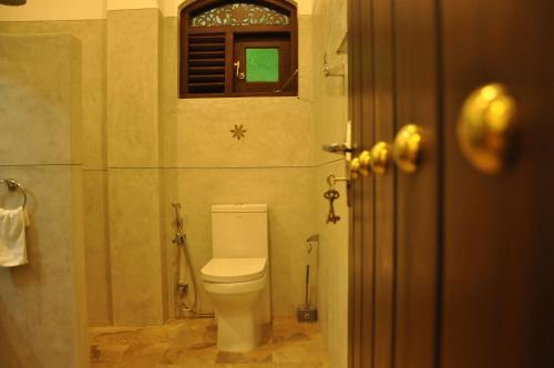 a bathroom with a toilet and a window at Green Villa Unawatuna in Unawatuna