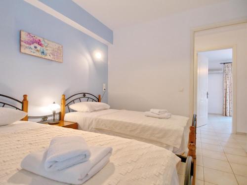 two beds in a room with two white beds at Villa Afroditi, Spartia, Kefalonia in Kefallonia