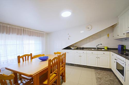 une cuisine avec une table en bois et une salle à manger dans l'établissement Apartamento Cacheiro, à Dena