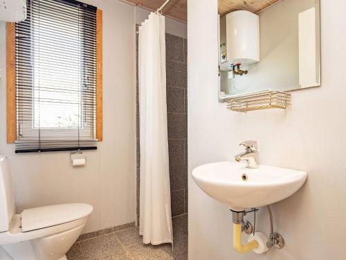 uma casa de banho com um lavatório, um WC e um espelho. em Holiday home Thyholm XVI em Thyholm
