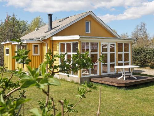 a yellow house with a picnic table in the yard at Tranquil Nature Escape-By Traum in Thyholm