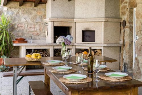 a wooden table with plates and wine glasses on it at Casa de Ferreira Cinfães in Cinfães
