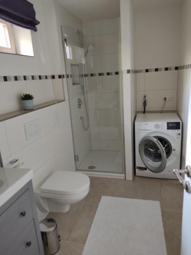 a bathroom with a toilet and a washing machine at Ferienwohnung mit Herz in Bad Tölz