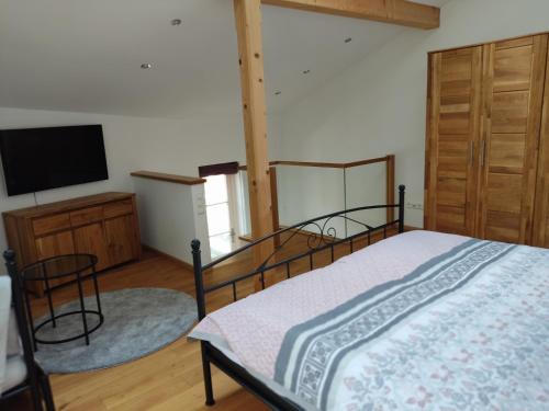 Schlafzimmer mit einem Bett und einem Flachbild-TV in der Unterkunft Ferienwohnung mit Herz in Bad Tölz