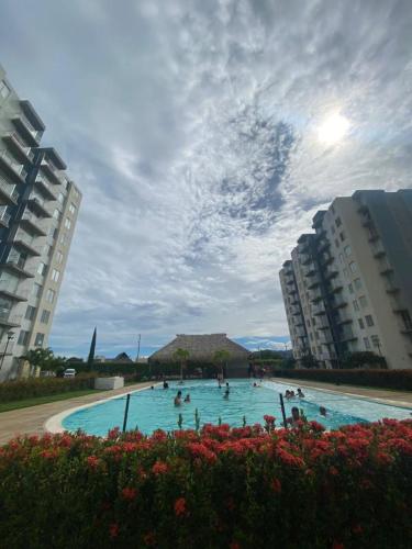a large swimming pool with people in it with buildings at Apartamento amplio y tranquilo en Flandes, Tolima in Flandes