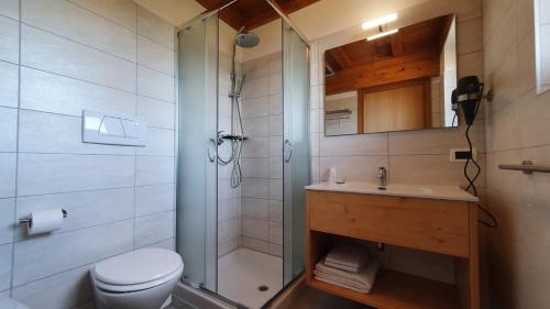 a bathroom with a shower and a toilet and a sink at La Montanina Hotel in Val di Non in Malosco