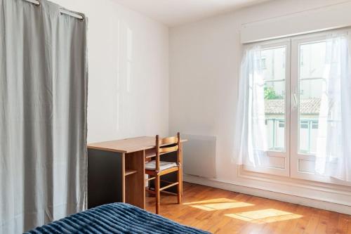 um quarto com uma secretária e uma janela em Charmant T2 proximité Paquebot-les Halles em Saint-Nazaire
