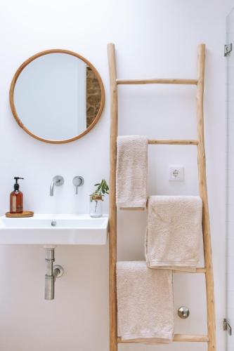 a bathroom with a ladder towel rack next to a sink at Quintal Country Houses in Vila Praia de Âncora