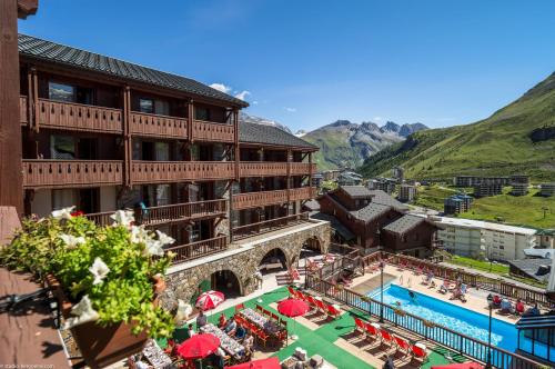 ein Gebäude mit einem Pool und einem Resort in der Unterkunft Hôtel Village Montana by Les Etincelles in Tignes