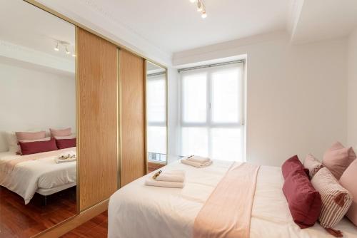 a bedroom with two beds and a large mirror at Plazuela Sta Catalina I en Mundaka By Kabia Gestión in Mundaka