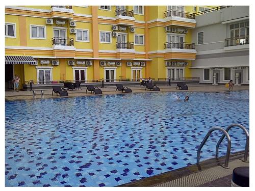 a large swimming pool in front of a building at Apartemen MTC in Manado