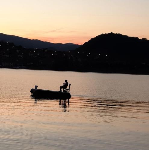 a man sitting on a boat in the middle of a lake at CHALET Orsova in Orşova
