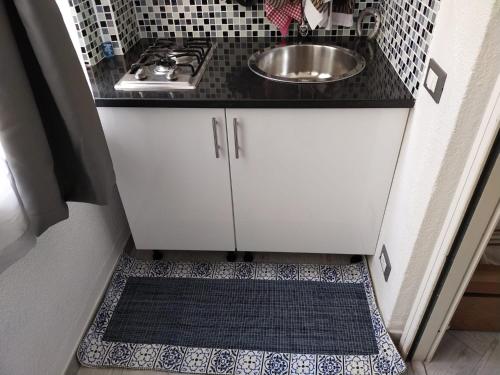 a small kitchen with a sink and a tile floor at Residence _Capo Gallo in Palermo