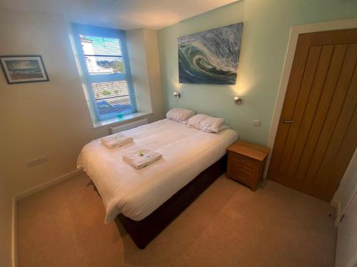 a bedroom with a bed with two towels on it at Pass the Keys Classy 2 bedroom apartment amazing beach views in Torquay