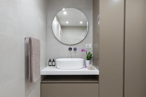 ein Bad mit einem Waschbecken und einem Spiegel in der Unterkunft Porto Azzurro Suite - Goelba in Porto Azzurro