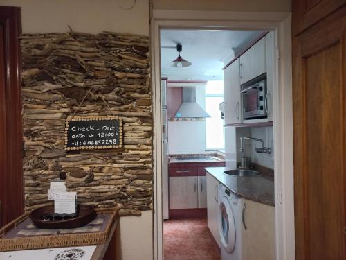 a kitchen with a stone wall with a sign on it at Precioso apartamento en Santander cerca de todo in Santander
