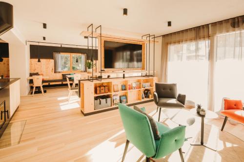 a living room with a television and a table and chairs at Alpin - Studios & Suites in Warth am Arlberg
