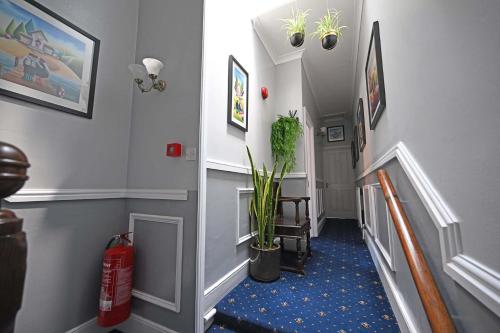 a hallway with a stairway with a fire hydrant and a plant at The Hathaways in Stratford-upon-Avon