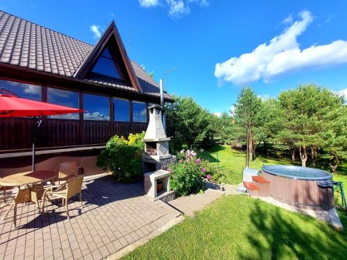 a house with a picnic table and a fire place at Sodyba Vilagio in Alanta