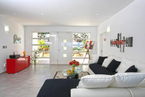 a living room with a white couch and a red cabinet at Villa Bel Amour, luxury and awesome sea view in Upper Prince's Quarter