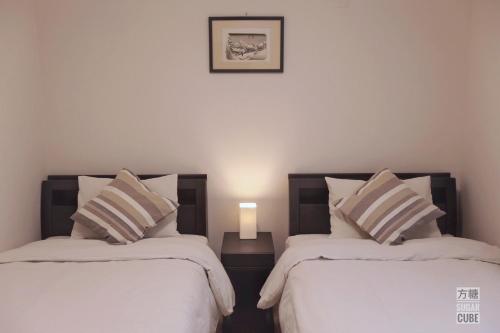 a bedroom with two beds and a picture on the wall at Furano CUBE SUGAR-方糖民宿,步行8min到雪场,3 brs,Max 6ppl in Furano