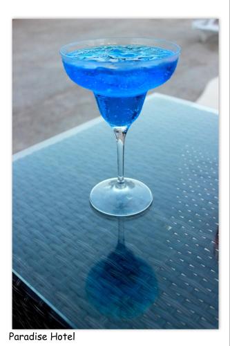 a blue drink in a martini glass on a table at Paradise Apartments Studios in Mylopotas
