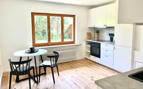 een keuken met een tafel en stoelen en een raam bij Bungalow in Rottachs Bestlage in Rottach-Egern