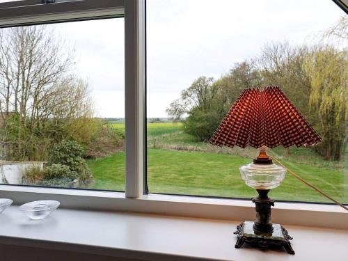 una lámpara sentada en una mesa frente a una ventana en 8 person holiday home in Fur en Fur