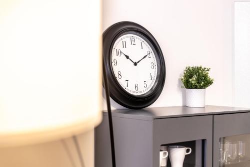 a clock on top of a cabinet with a plant at Munich Home in Munich
